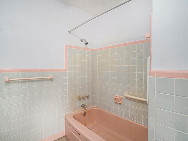 full bathroom featuring wainscoting, shower / bath combination, and tile walls