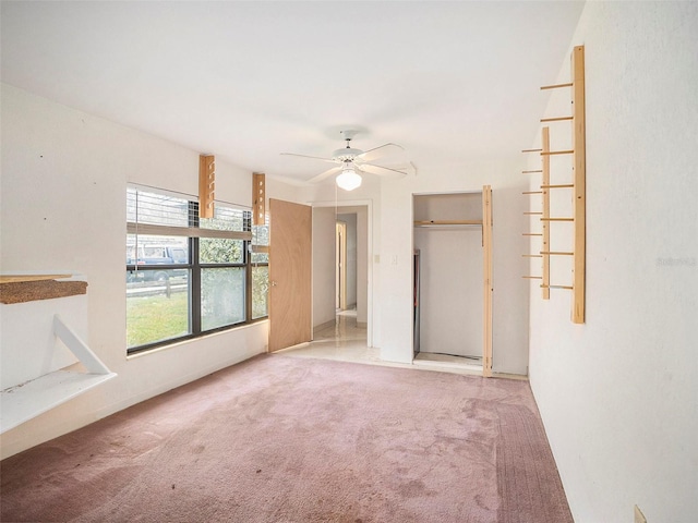 carpeted spare room with a ceiling fan