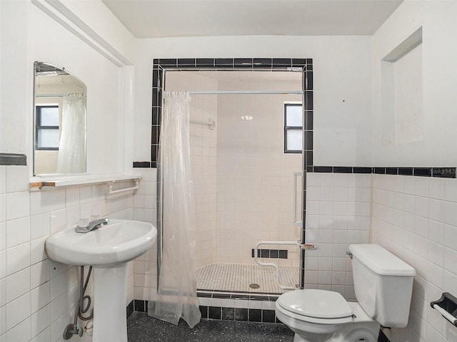 bathroom featuring a stall shower, plenty of natural light, tile walls, and toilet