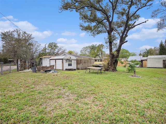 view of yard with an outbuilding, fence, and a storage unit