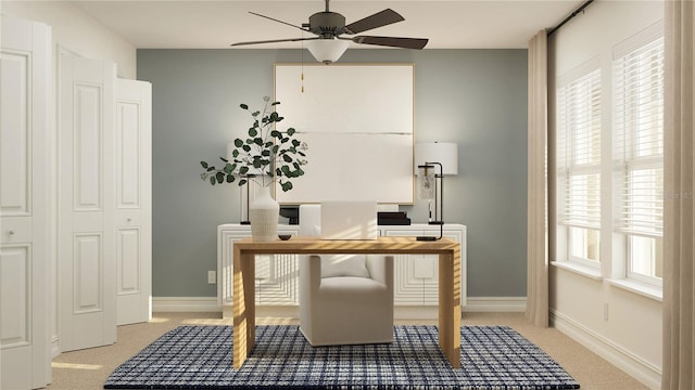 office area featuring light carpet, baseboards, and a ceiling fan