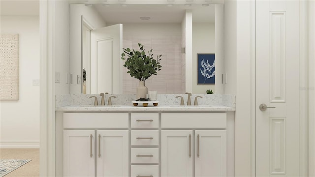 bathroom with double vanity, a sink, and baseboards