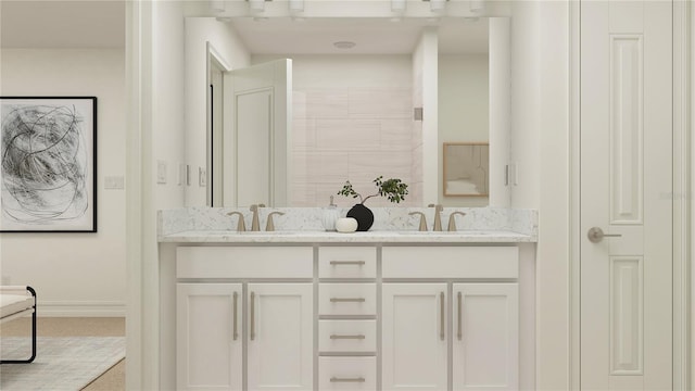 bathroom featuring tiled shower, a sink, baseboards, and double vanity