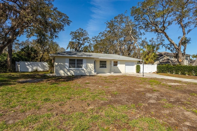 view of front of property with a garage, driveway, a front lawn, and fence