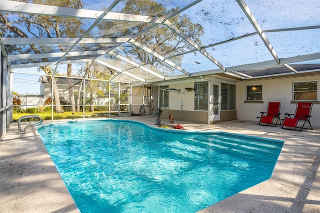 pool with a patio area, a sunroom, and glass enclosure