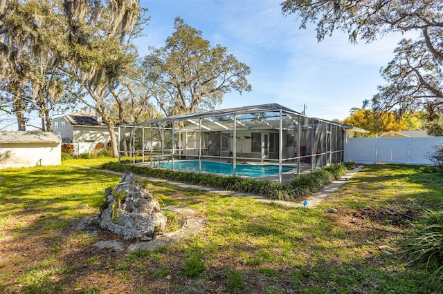 back of house featuring a fenced in pool, a lanai, a fenced backyard, and a lawn