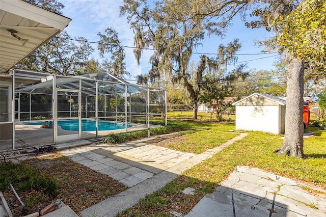 view of yard with an outbuilding, a patio area, an outdoor pool, and a storage shed