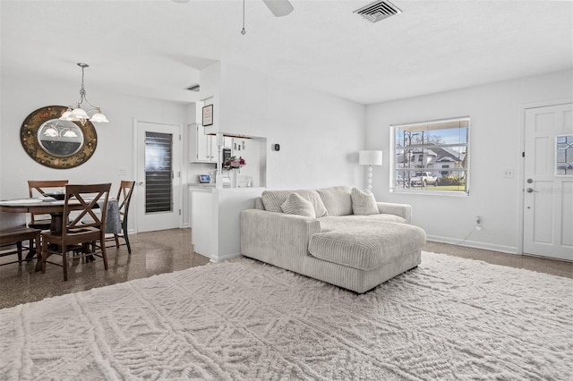 living room with baseboards, visible vents, and a ceiling fan