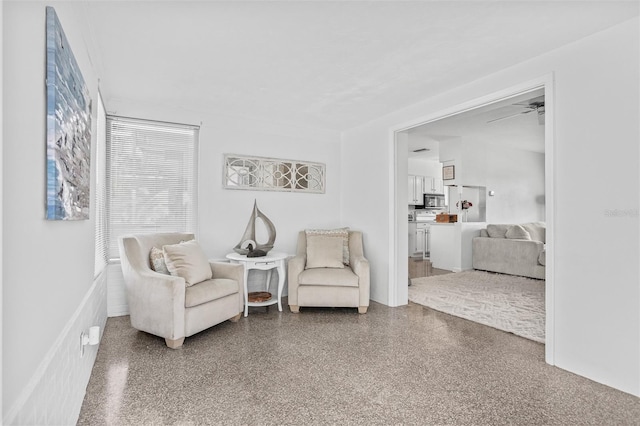 sitting room with ceiling fan and speckled floor