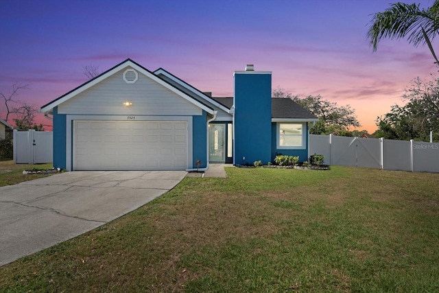 ranch-style house with a yard, a chimney, concrete driveway, an attached garage, and a gate