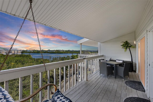 wooden deck featuring outdoor dining space and a water view