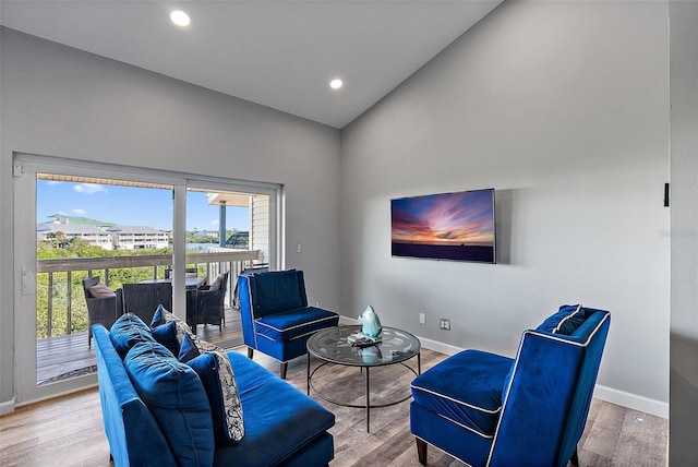 living area with high vaulted ceiling, baseboards, wood finished floors, and recessed lighting