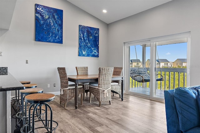 dining space with light wood-style floors, recessed lighting, vaulted ceiling, and baseboards