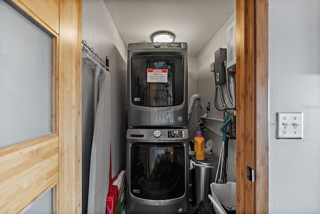 utility room with stacked washer / drying machine