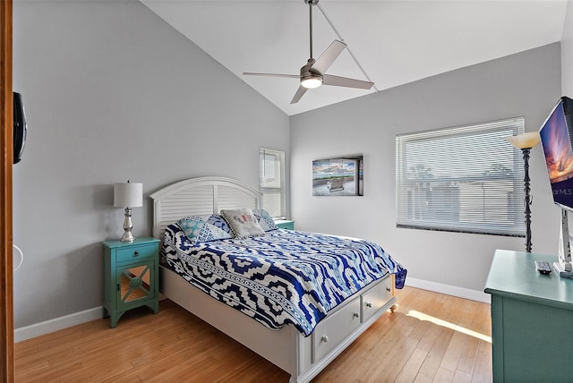 bedroom with light wood-style floors, vaulted ceiling, baseboards, and ceiling fan