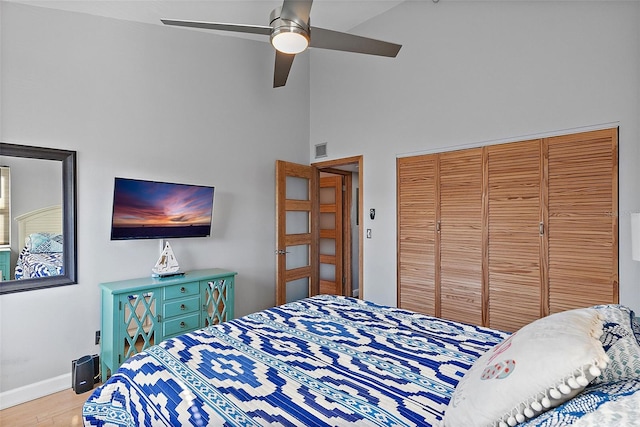 bedroom featuring a closet, visible vents, a ceiling fan, wood finished floors, and baseboards