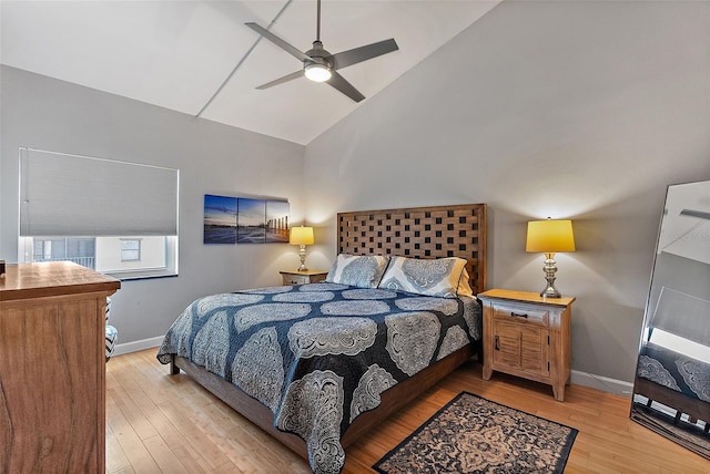 bedroom with light wood-type flooring, ceiling fan, baseboards, and lofted ceiling