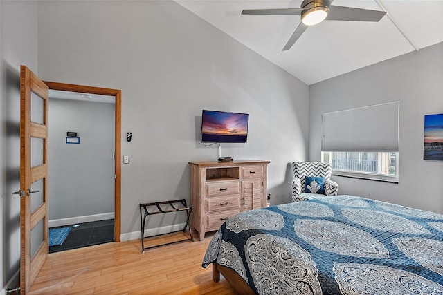 bedroom with lofted ceiling, a ceiling fan, baseboards, and wood finished floors