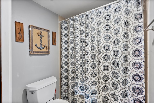 bathroom with curtained shower and toilet