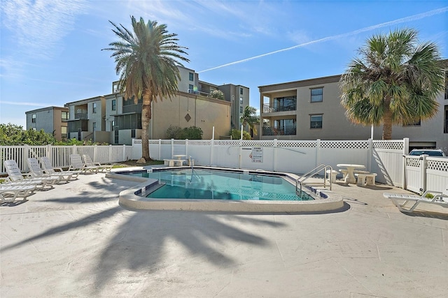 community pool featuring fence and a patio