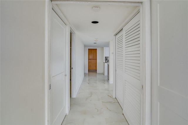 hallway with marble finish floor and baseboards