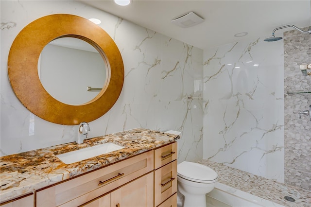 bathroom featuring vanity, a shower stall, and toilet