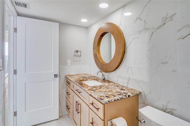 bathroom with toilet, vanity, visible vents, and recessed lighting