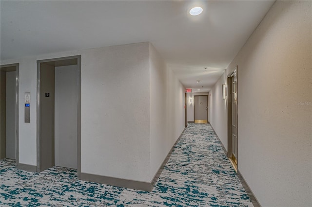 hall with carpet floors and elevator