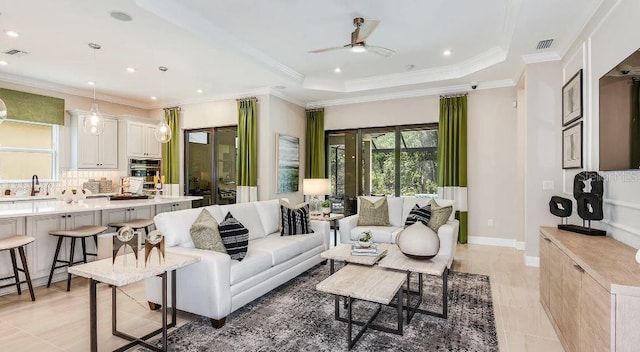 living room featuring ornamental molding, a raised ceiling, and visible vents