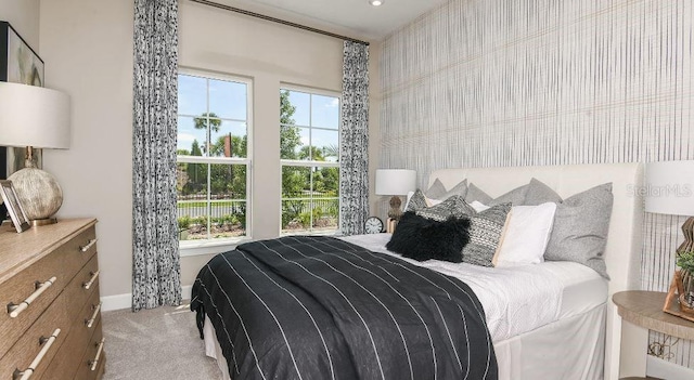 bedroom featuring baseboards and light colored carpet