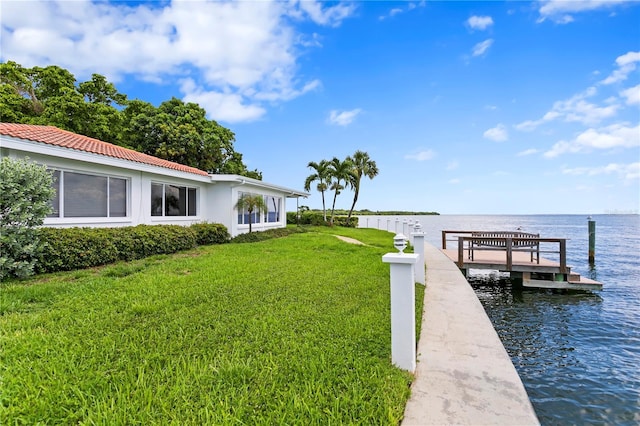 view of dock with a water view and a yard