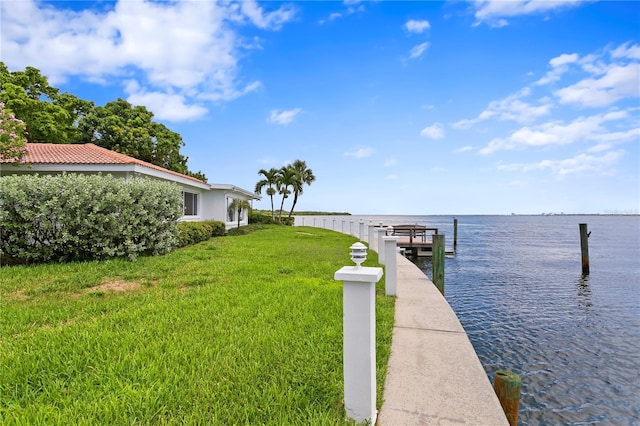 dock area with a water view and a yard