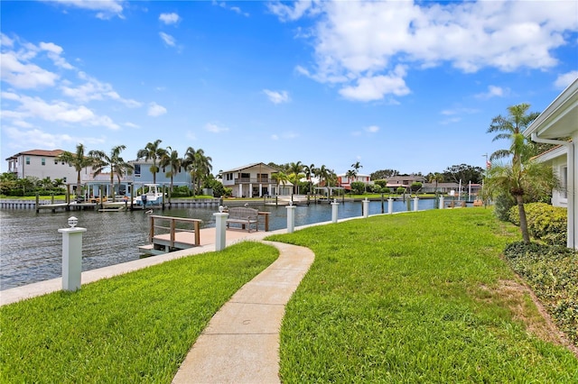 dock area with a water view, a residential view, and a yard