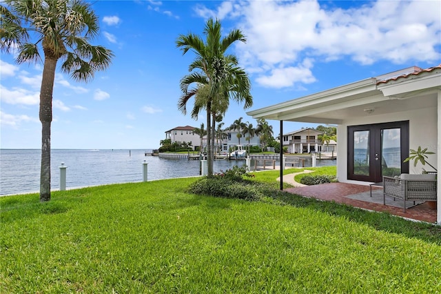 view of yard featuring french doors and a water view