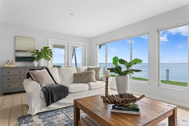 living room featuring a water view, baseboards, french doors, and light tile patterned flooring