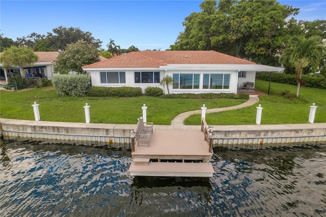 back of house featuring a water view and a yard