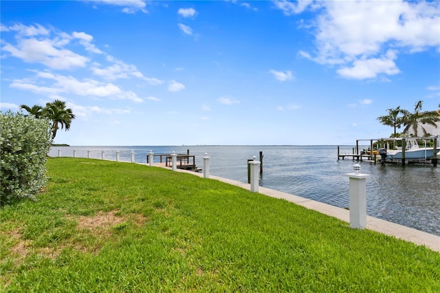 view of dock featuring a water view and a yard