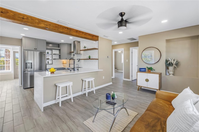 living area featuring light wood-style floors, a ceiling fan, and recessed lighting
