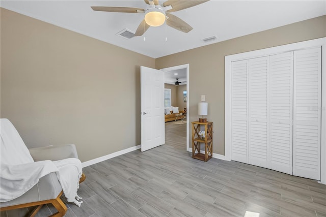 sitting room with baseboards, visible vents, and a ceiling fan
