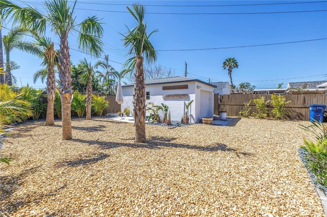 view of yard featuring an outdoor structure, a garage, and fence