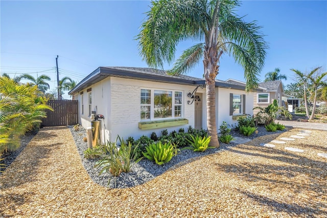 view of home's exterior with stucco siding and fence