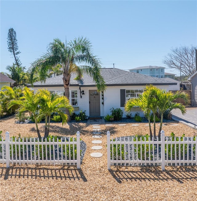 view of front of house with roof with shingles and a fenced front yard