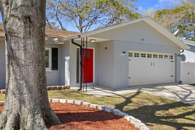 single story home with a garage, driveway, a shingled roof, and stucco siding