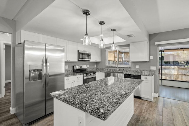 kitchen with a center island, dark wood-style flooring, stainless steel appliances, white cabinets, and a sink