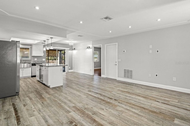 kitchen with visible vents, a kitchen island, white cabinetry, and stainless steel appliances