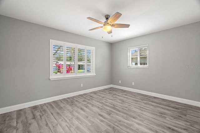 unfurnished room with light wood-style floors, ceiling fan, and baseboards