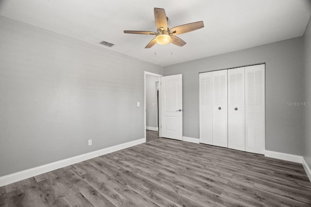 unfurnished bedroom with a ceiling fan, a closet, baseboards, and wood finished floors