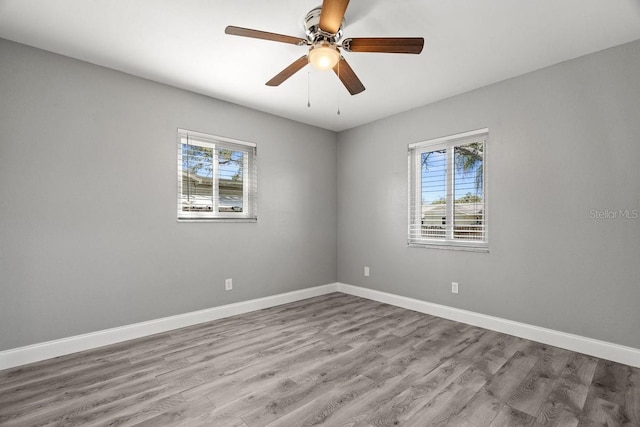 empty room with light wood-type flooring, plenty of natural light, baseboards, and ceiling fan