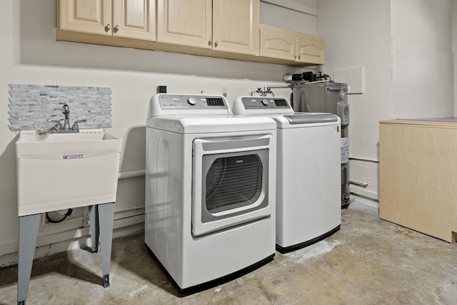 laundry room featuring electric water heater, a sink, washing machine and dryer, and cabinet space