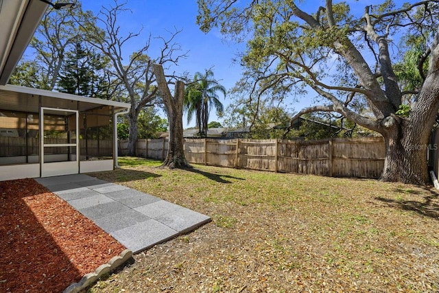 view of yard with a sunroom and a fenced backyard